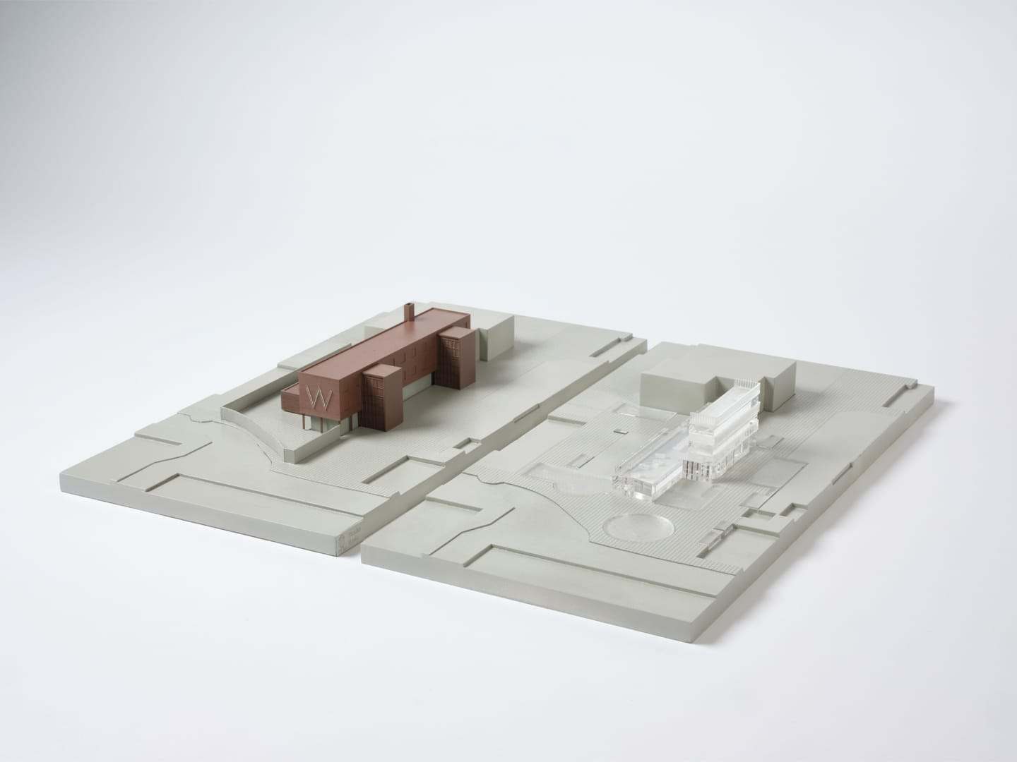 The two grey site bases side by side, with the brown building placed on one of them