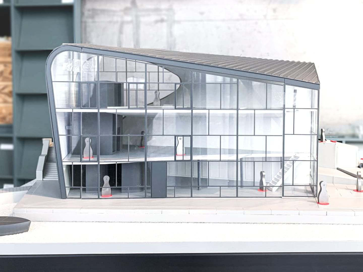 The side of the model, with the curved roof meeting the glass facade