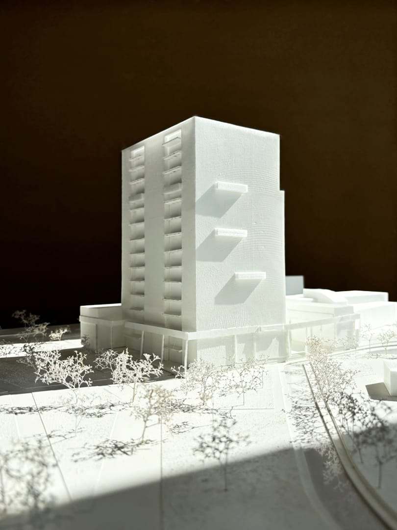 The tower rising above the plinth, with trees in front