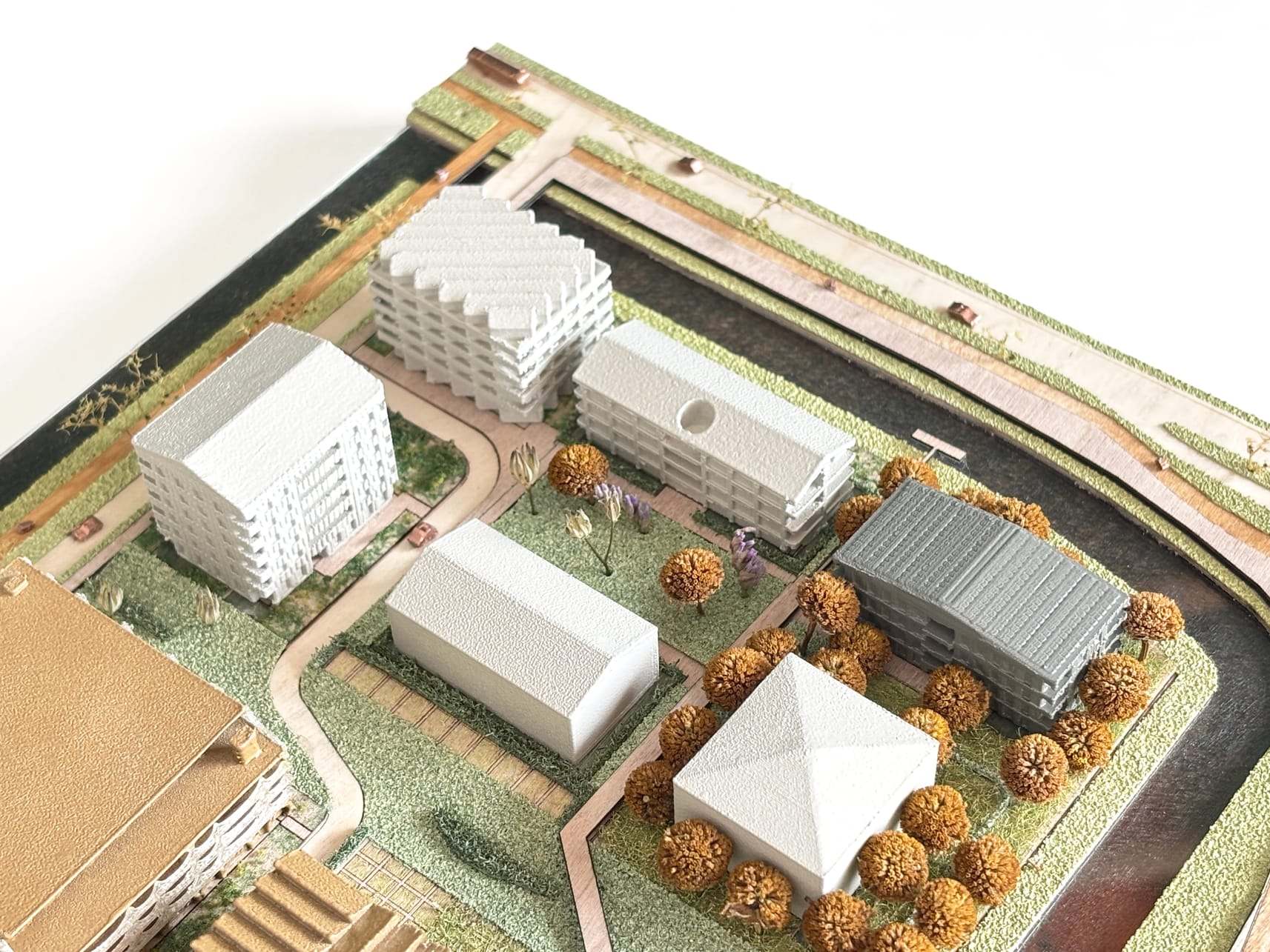 White apartment blocks and a pavilion between orange trees