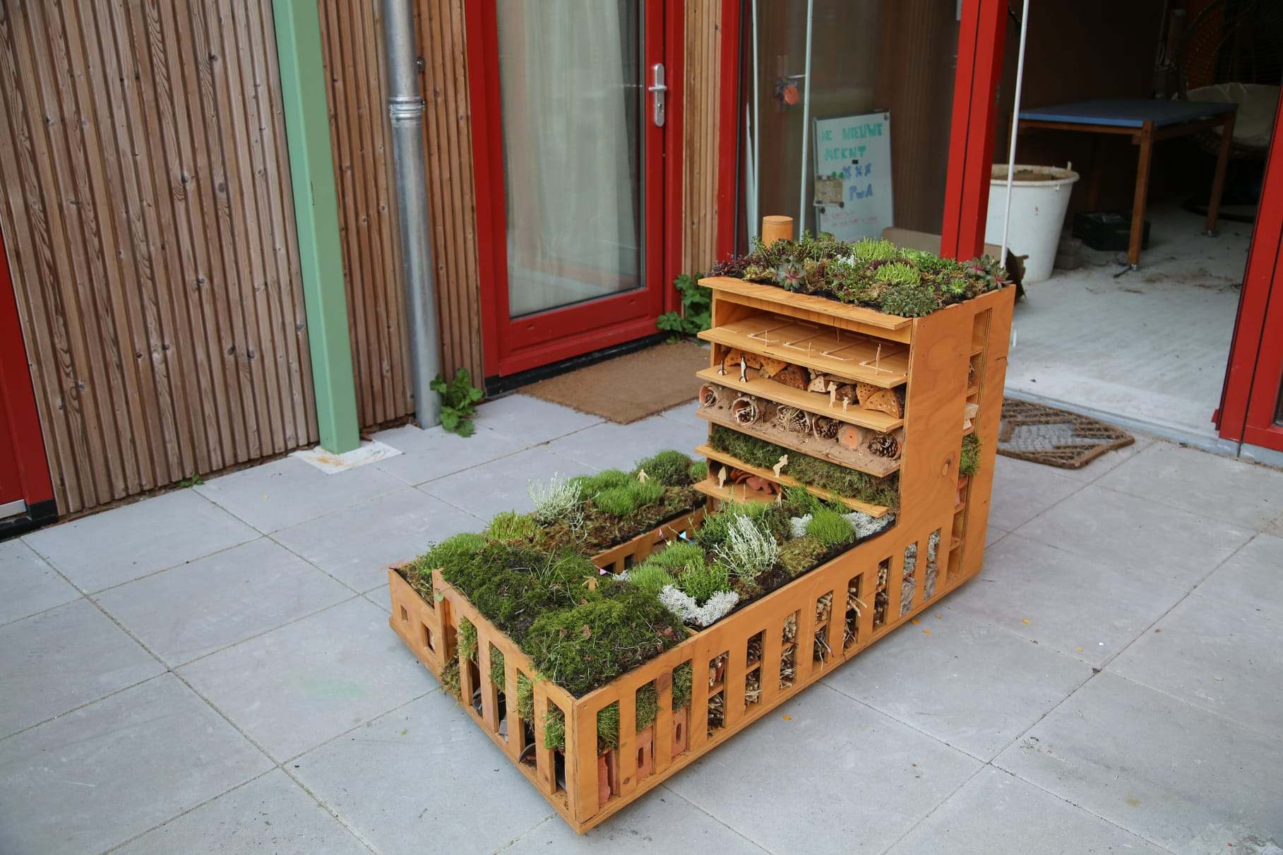 The object on the pavement, planted trays running along its base