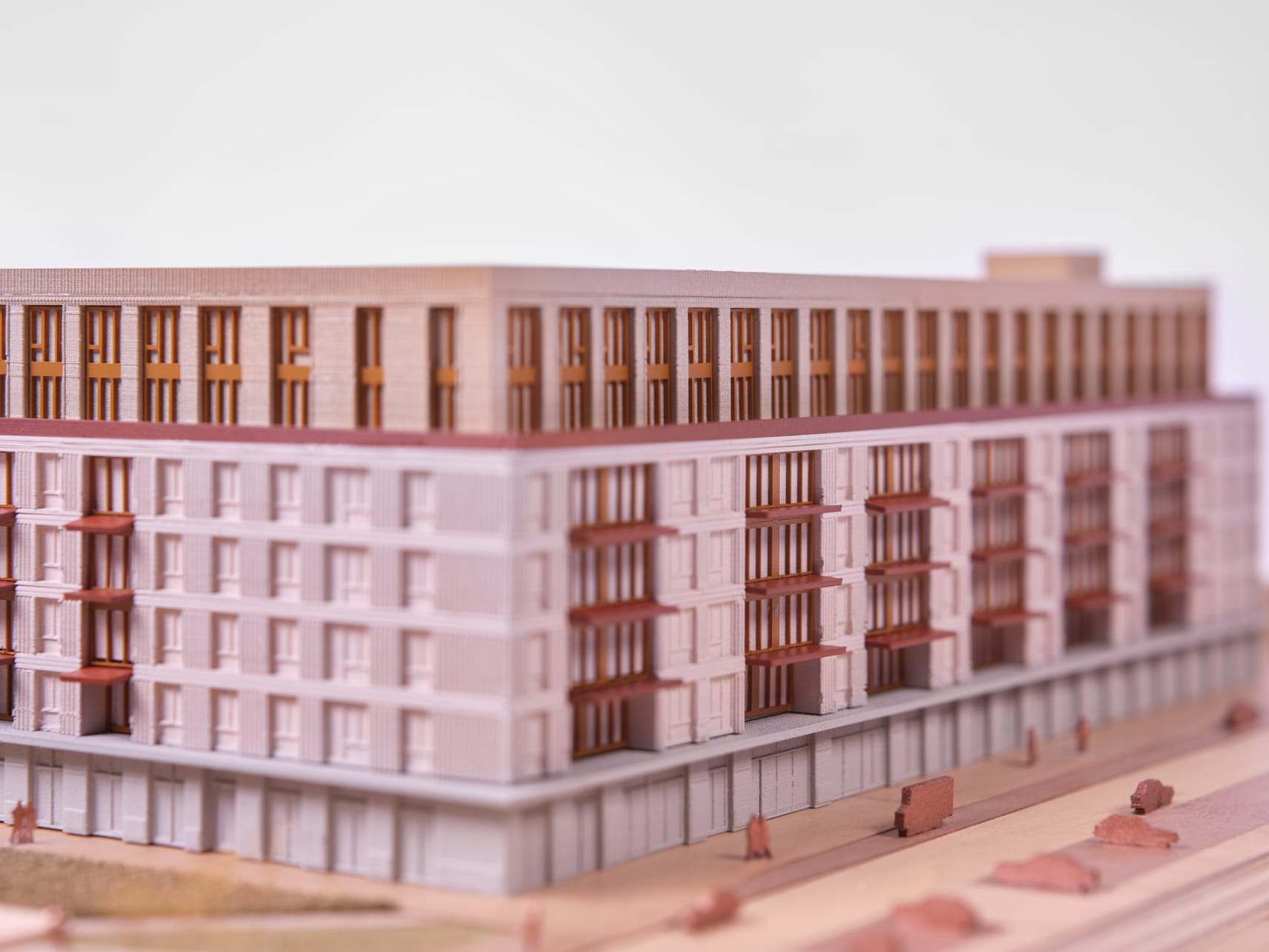 Corner of the De Bundel model with its facade of vertical fins in pink and copper tones