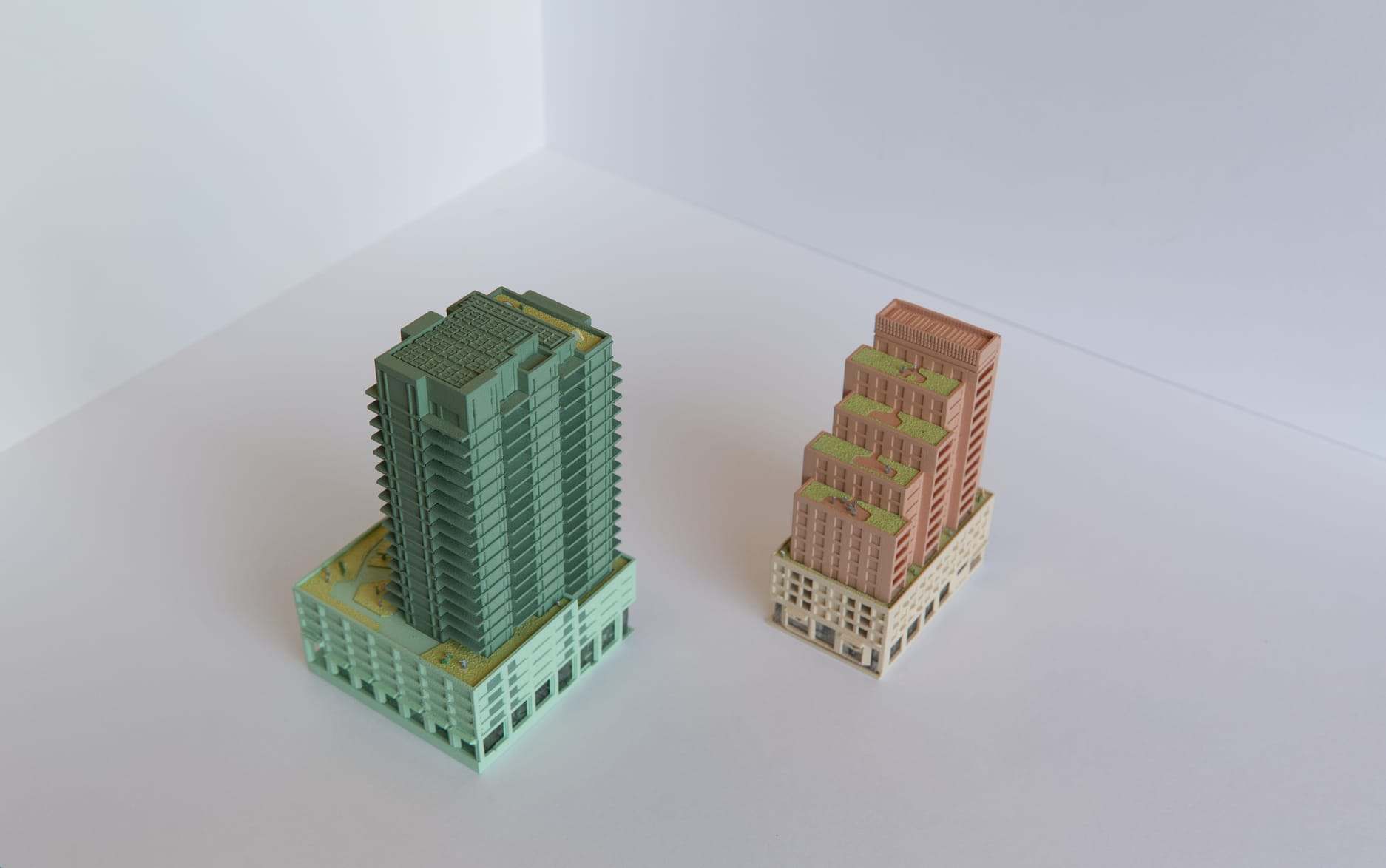 1:200 models of the green Markus tower and the pink Franka tower side by side on a white surface