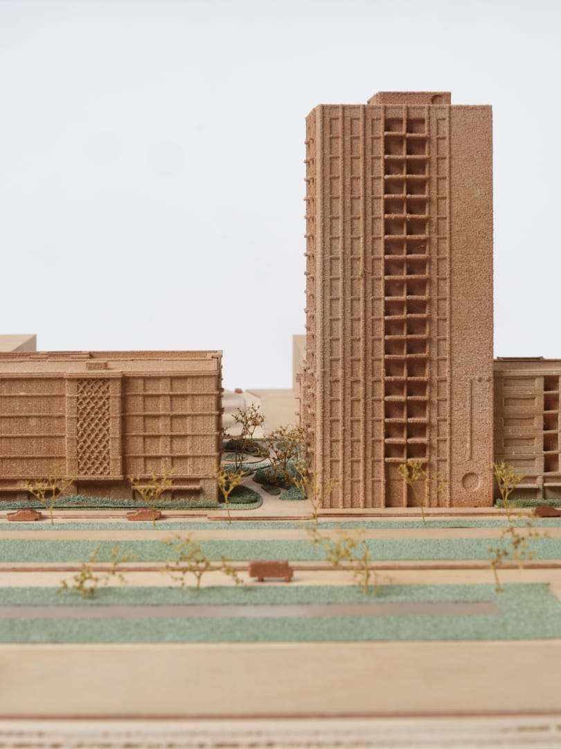 A tall tower of the De Vonk model beside a long housing block, seen from street level