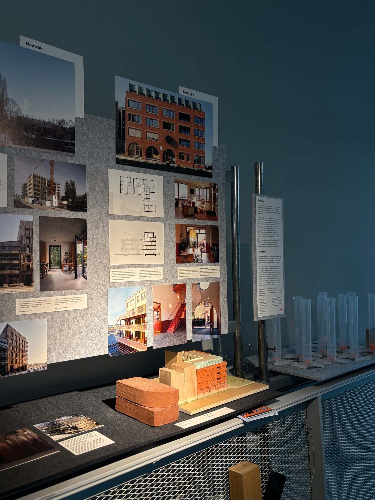 The Bakstayn model on display in an exhibition, in front of boards with images and drawings of the building