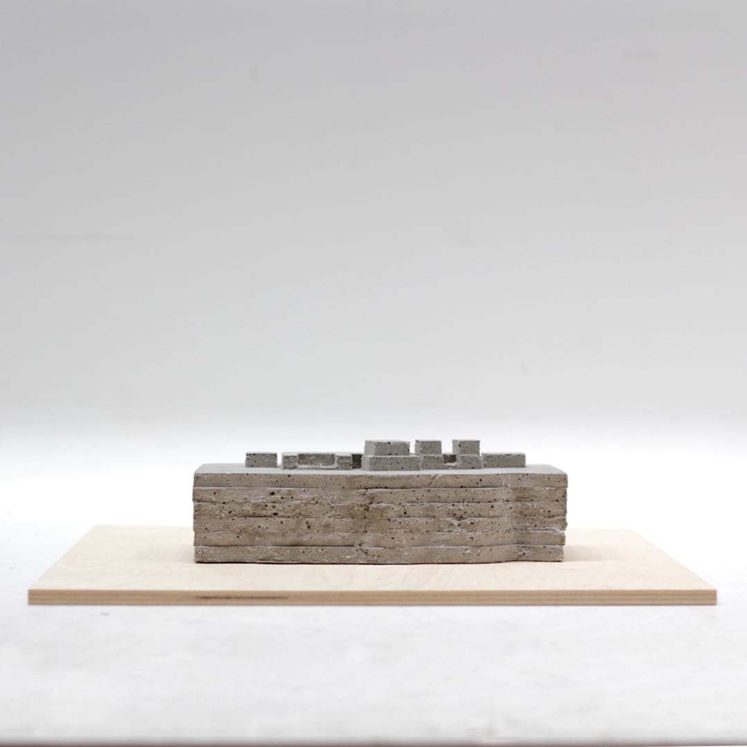 A concrete-grey study model on a plywood base