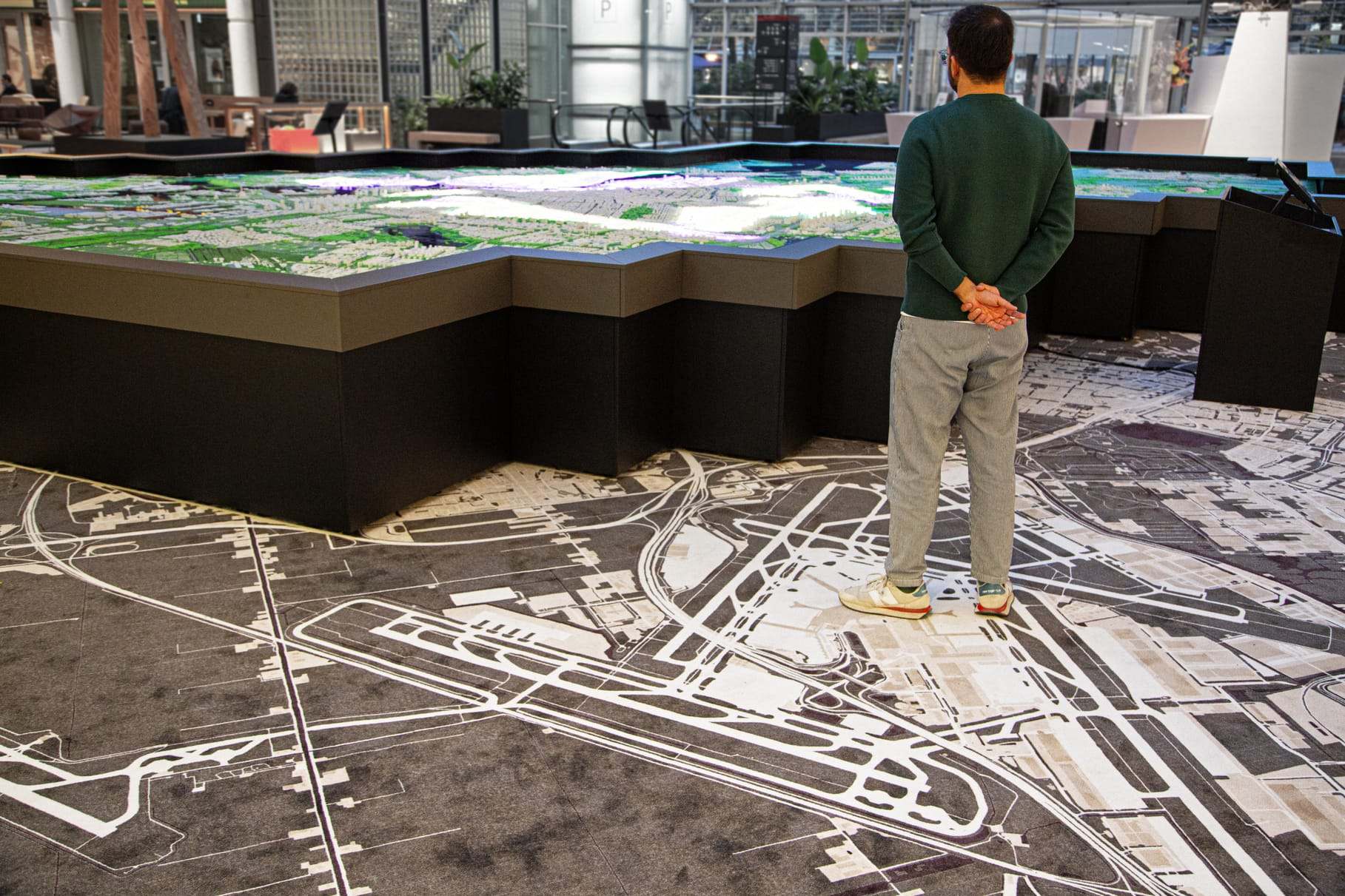 A visitor standing on the printed map that surrounds the model