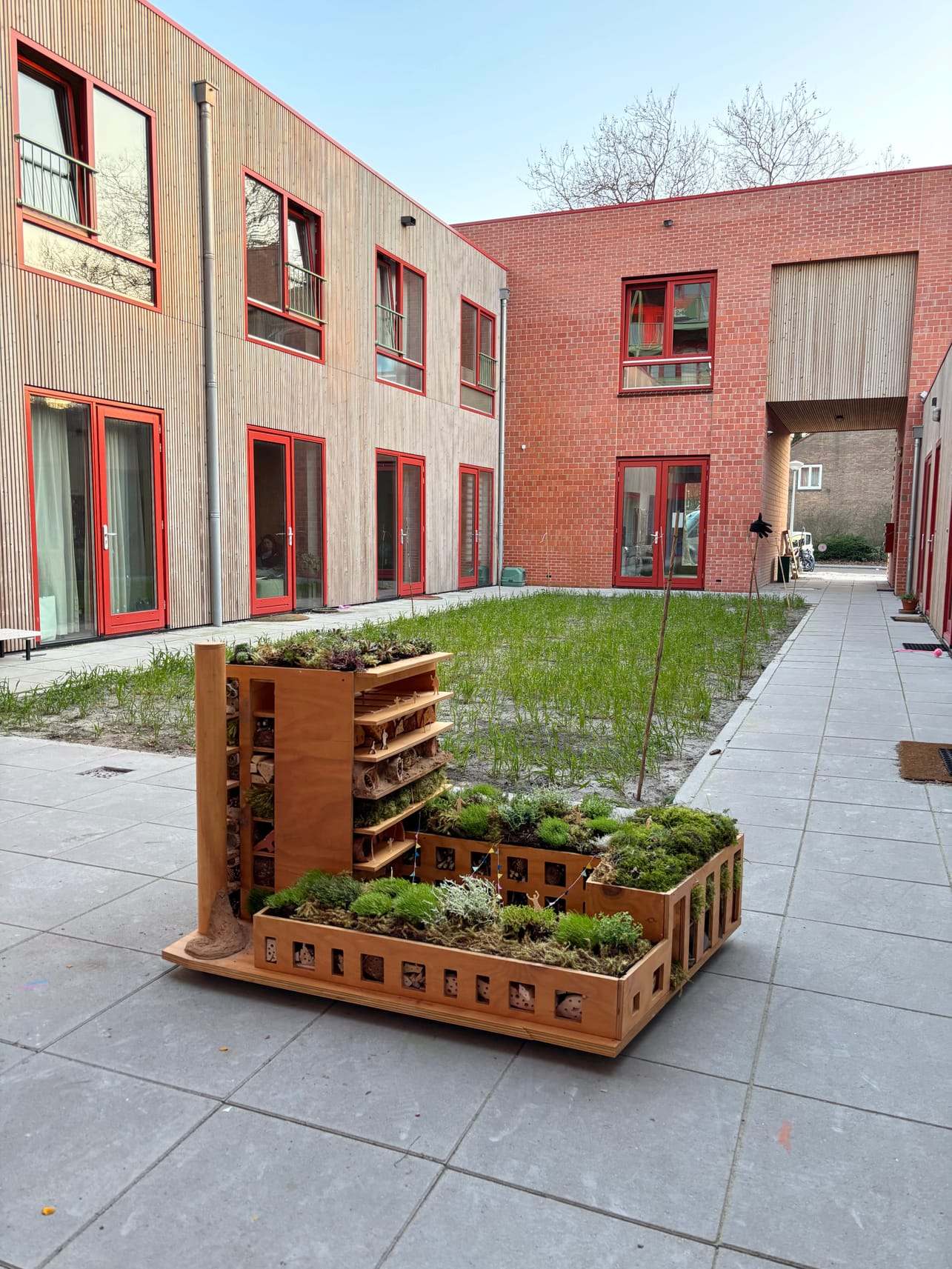 The insect hotel standing in the courtyard of De Nieuwe Meent, a brick housing block in Amsterdam