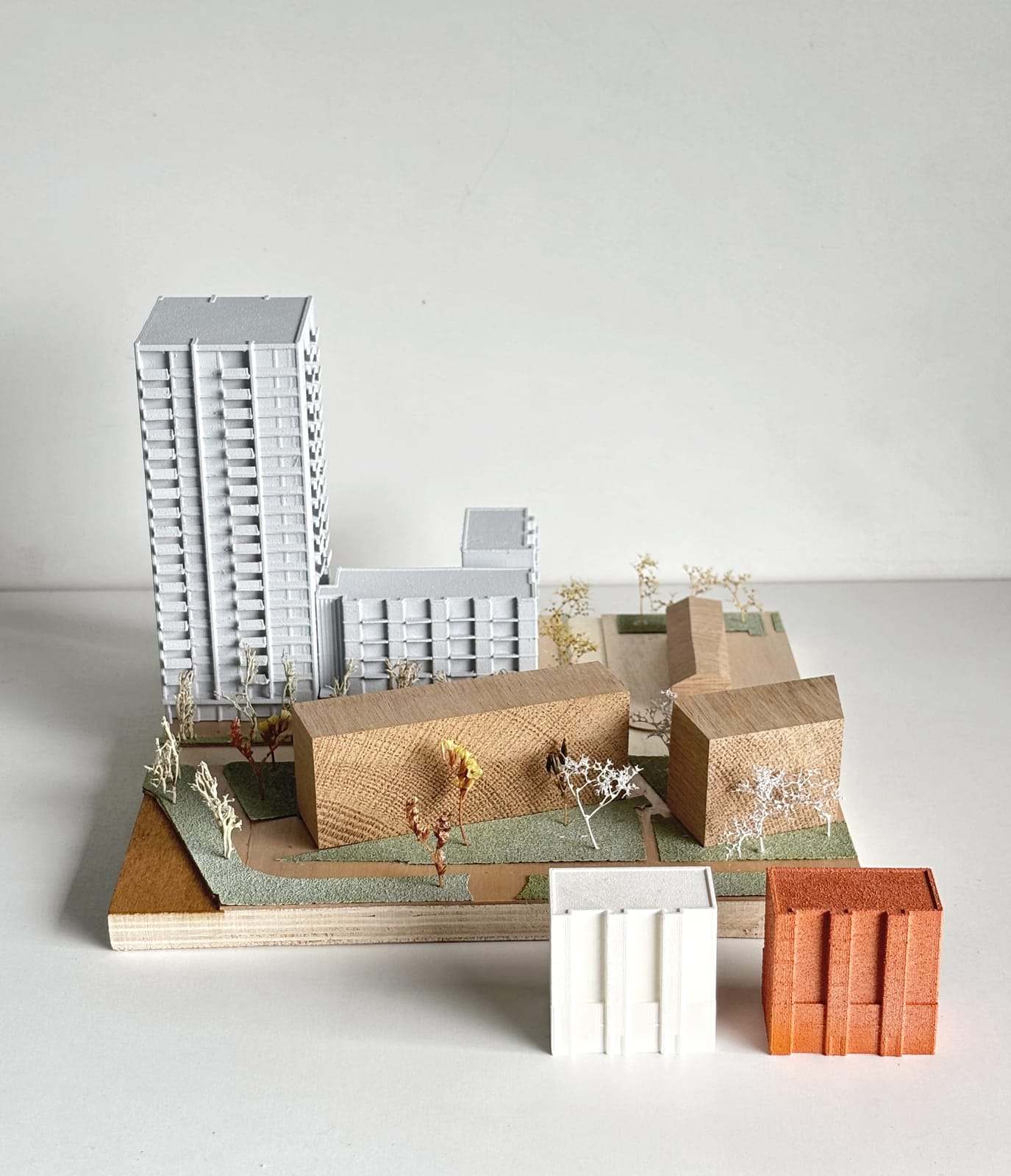 De Vonk site model in white with wooden volumes and small trees on a plywood base