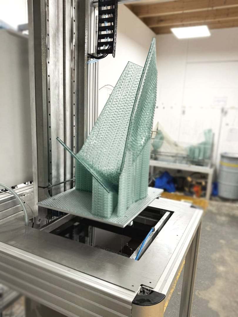A transparent 3D-printed tower rising from the printer platform