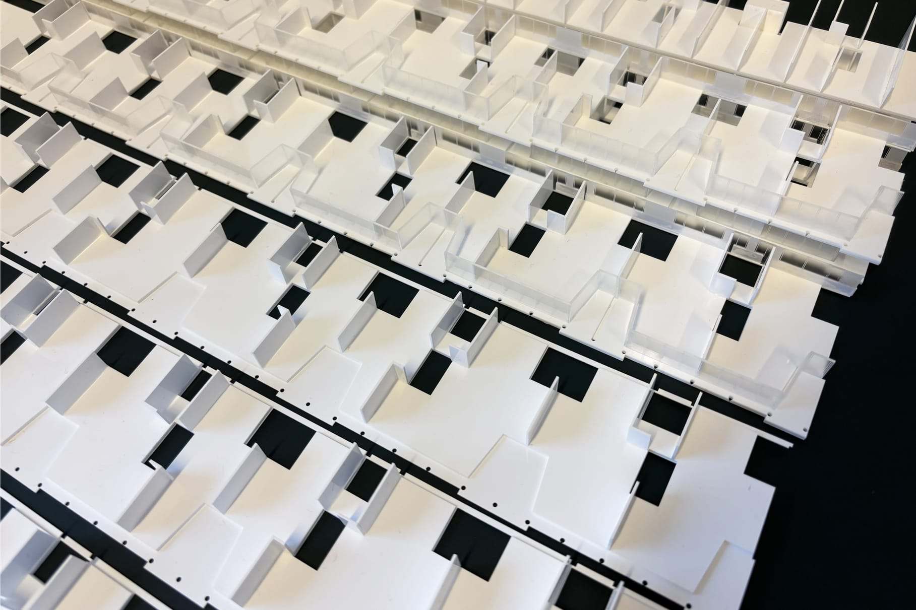 Rows of white balcony pieces with dark gaps, laid out before assembly