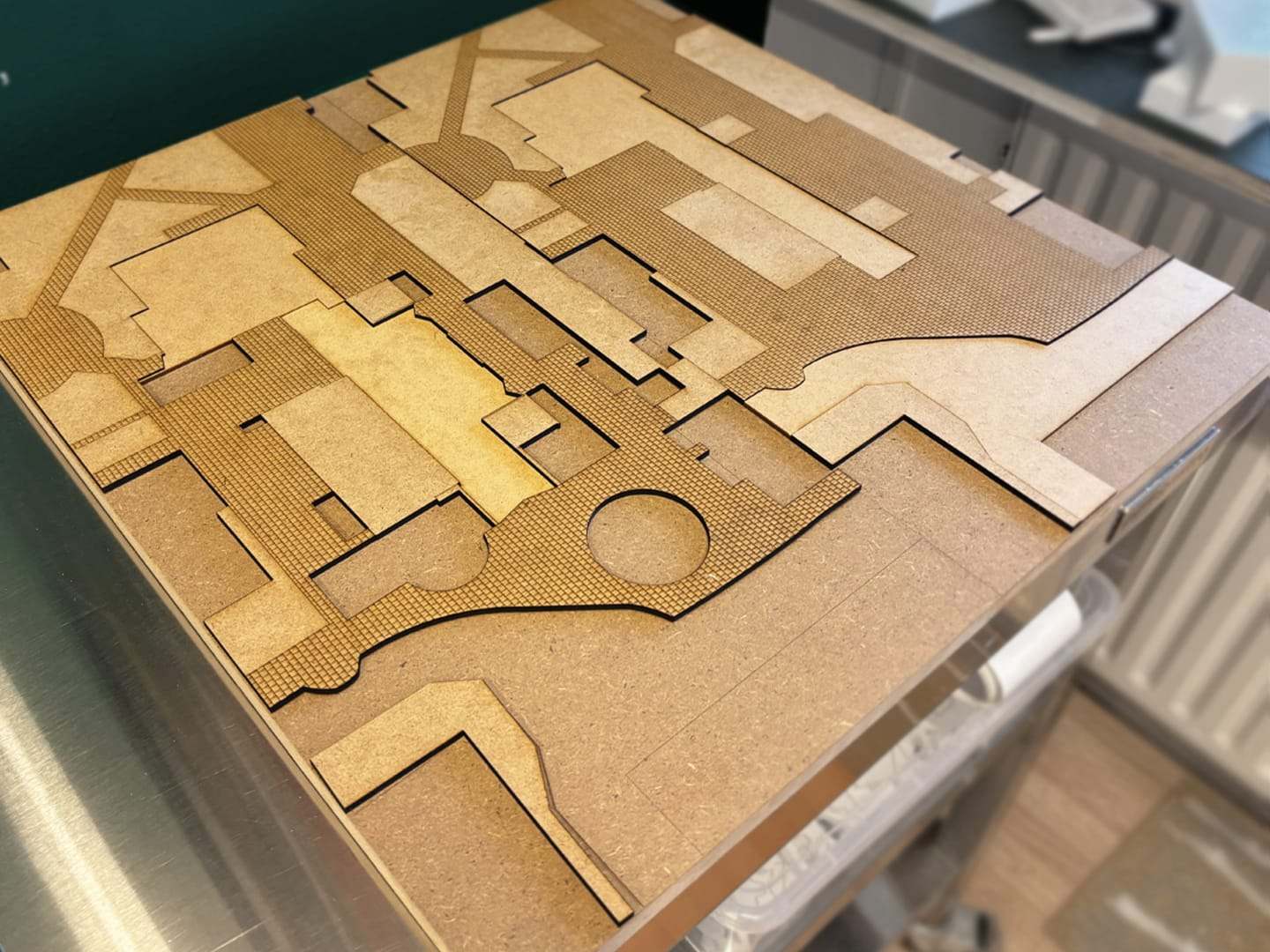The laser-cut MDF ground plate, layered up with the circular square cut into it