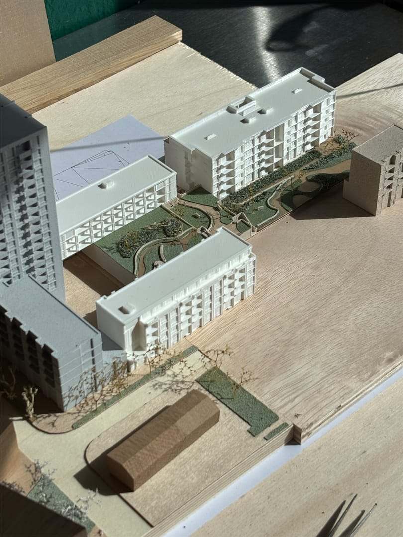Aerial view of the De Vonk model with white towers and a wooden barn-like volume