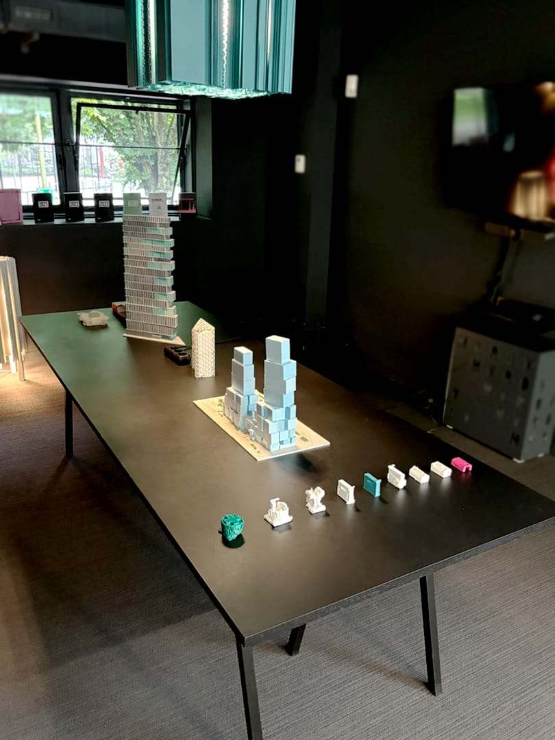 The finished model on a table at the office, next to another study model