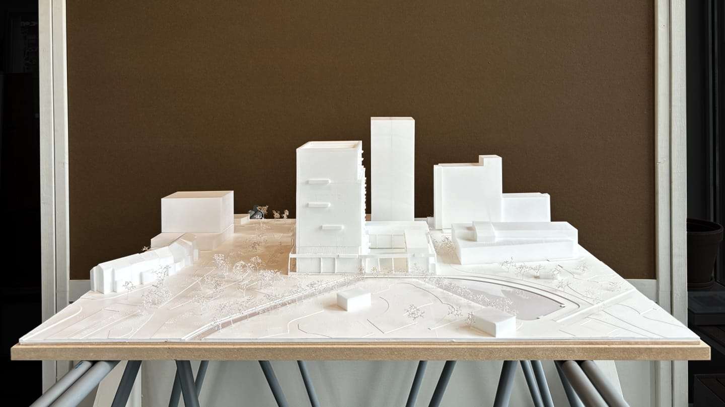 The whole model on its exhibition table, against a brown wall