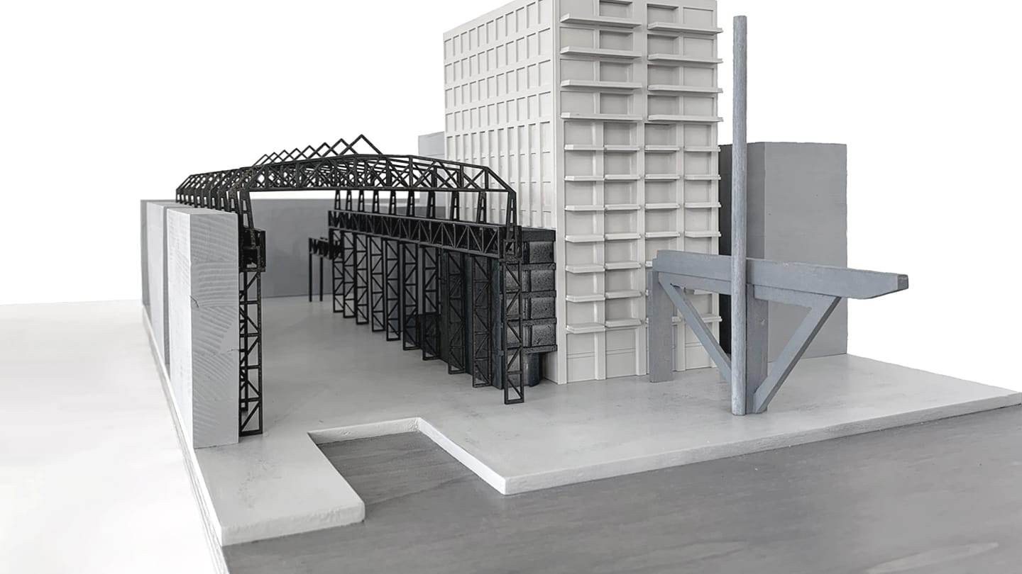 1:200 concept model of De Draaier: a white residential tower next to a black steel hall structure