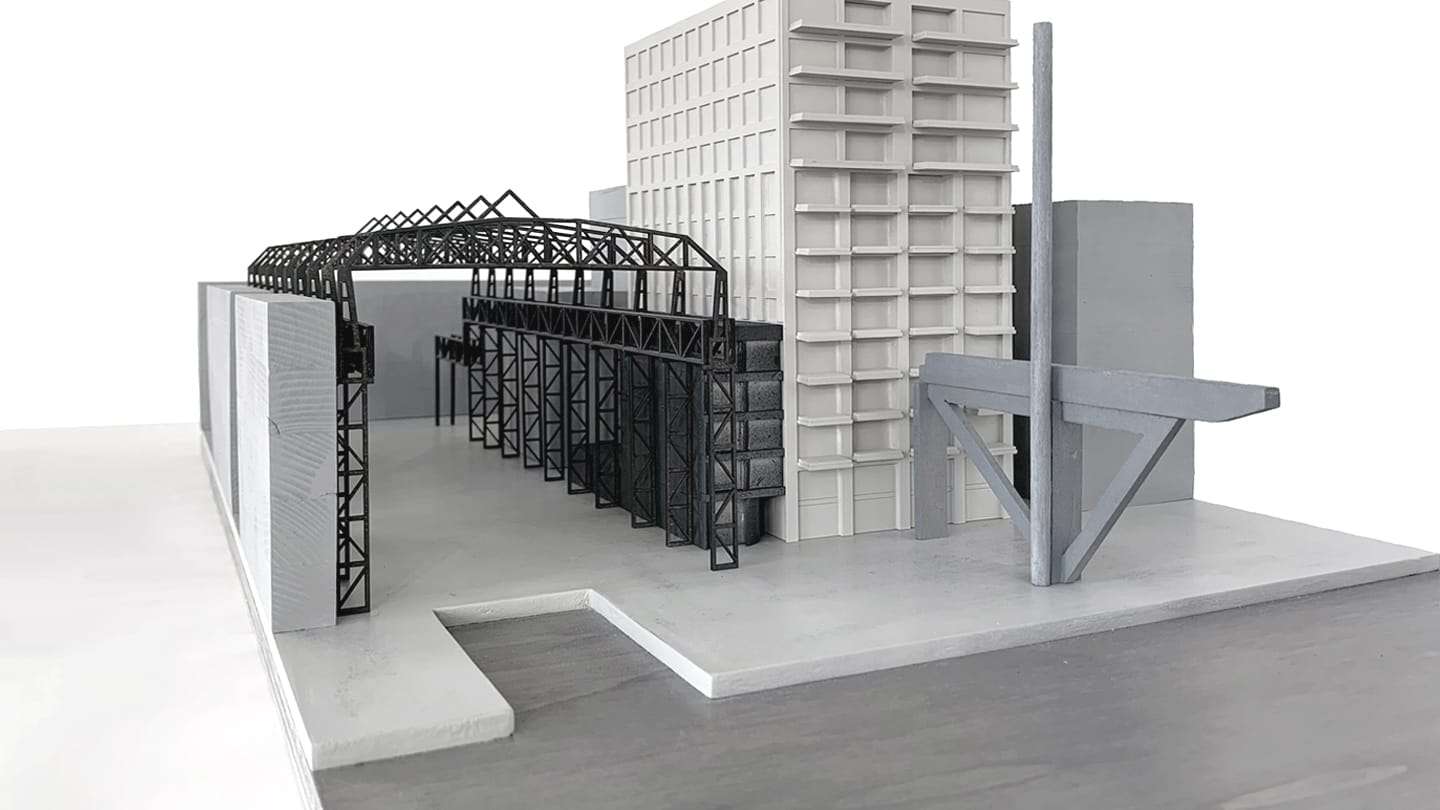 1:200 concept model of De Draaier: a white residential tower next to a black steel hall structure