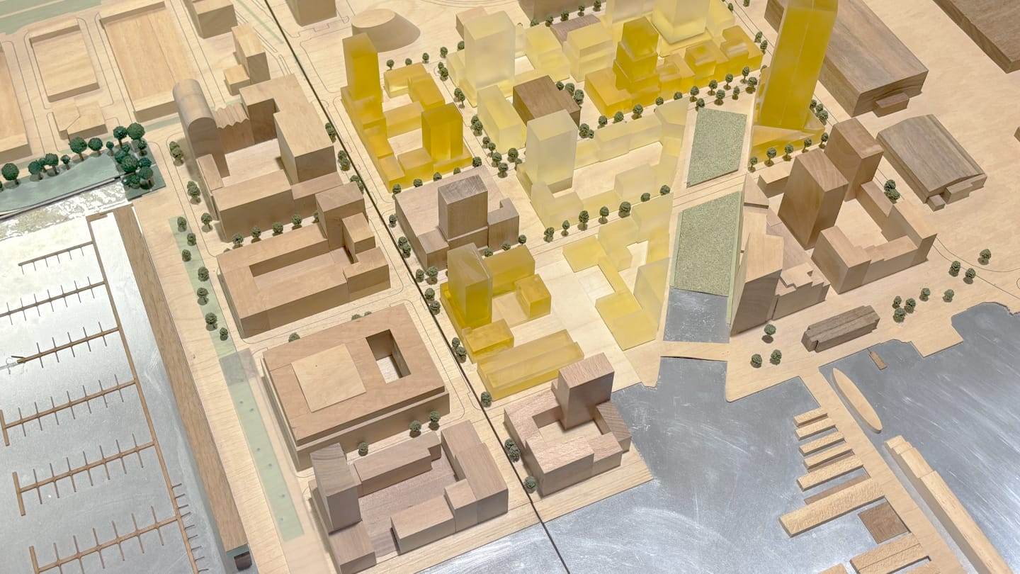 1:1000 model of the NDSM wharf: amber acrylic volumes among timber blocks along the IJ