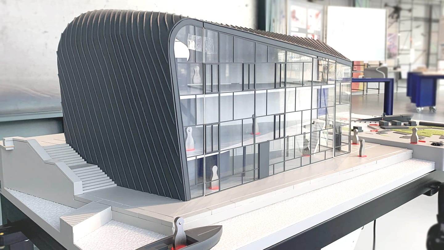 Model of the ARCAM pavilion: a ribbed aluminium shell wrapping a glass facade