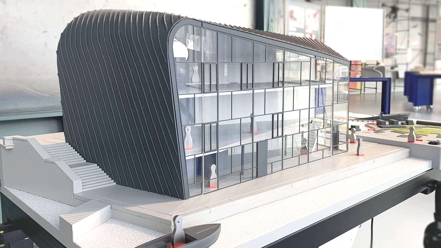 Model of the ARCAM pavilion: a ribbed aluminium shell wrapping a glass facade