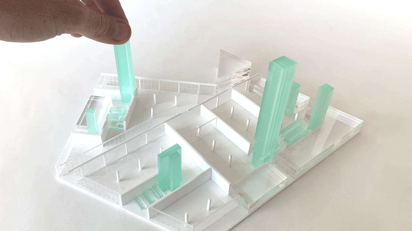 A hand placing a green acrylic core into the white grid of the model