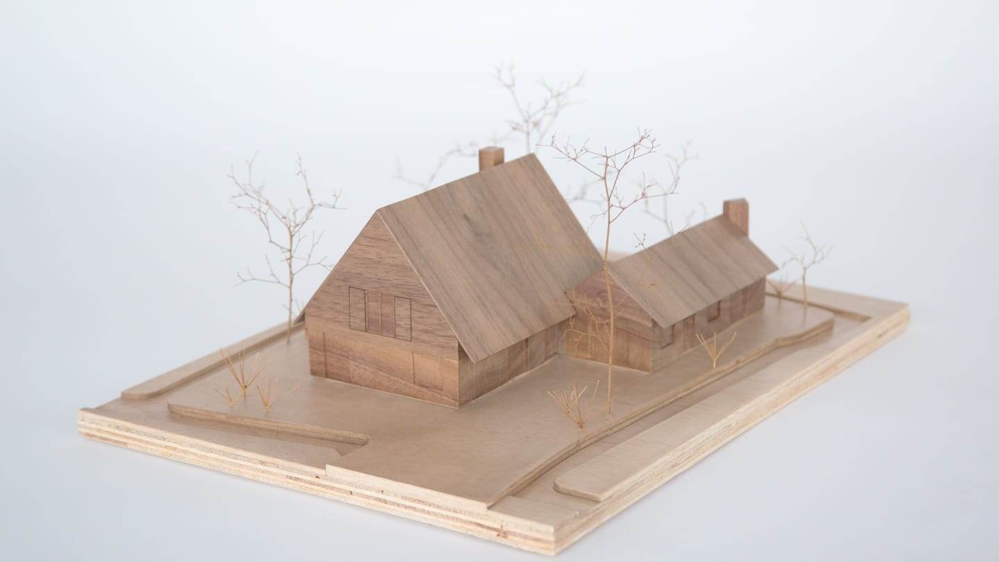 1:100 model of Villa Voorwerf carved from solid walnut, standing on a plywood base with dried branches