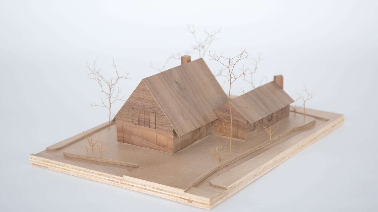 1:100 model of Villa Voorwerf carved from solid walnut, standing on a plywood base with dried branches