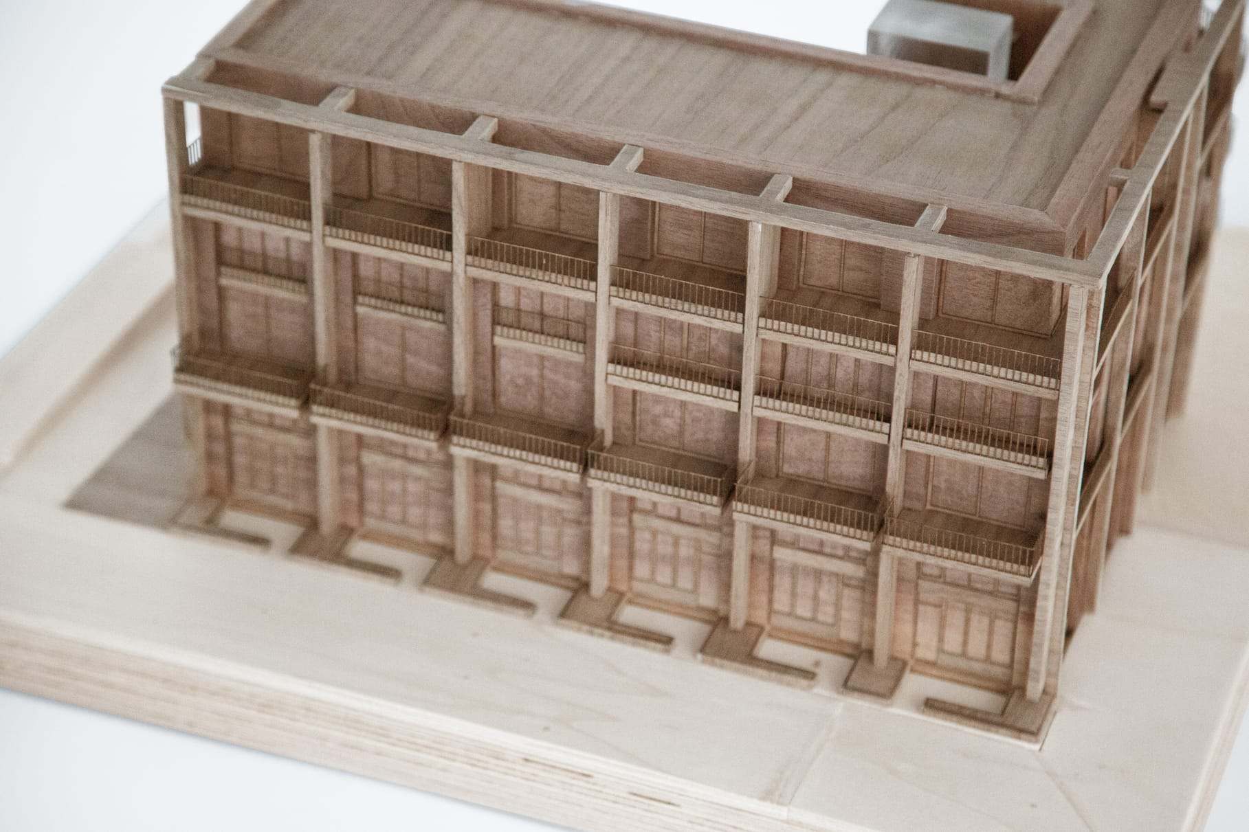 Close-up of the walnut facade grid, with the deep window reveals cut into the solid wood