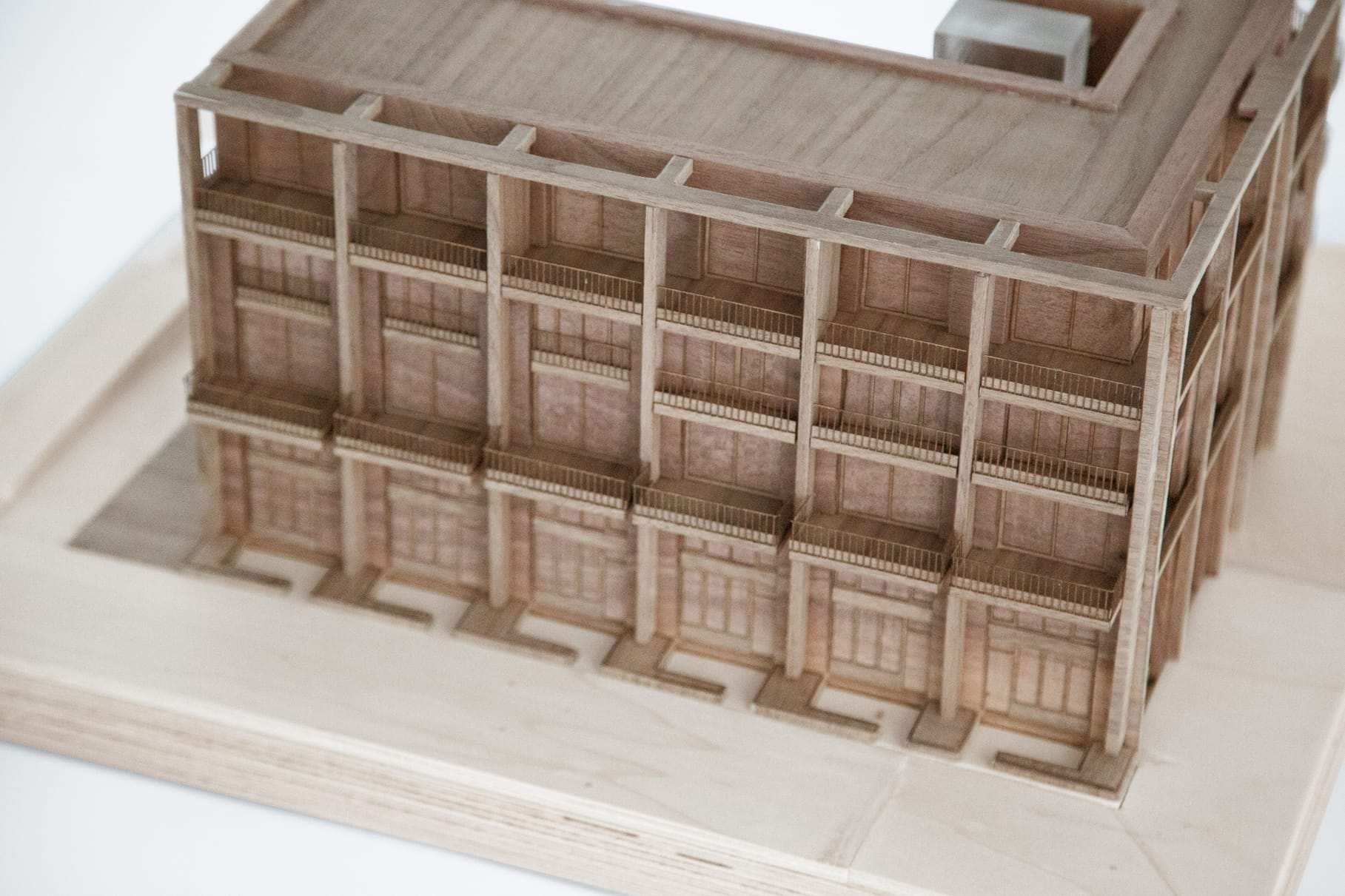 Close-up of the walnut facade grid, with the deep window reveals cut into the solid wood