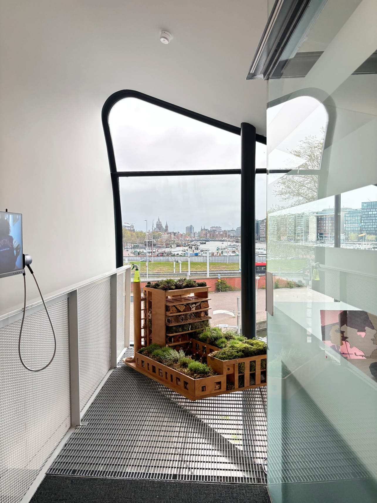 The insect hotel in the ARCAM gallery, with the Amsterdam skyline through the window